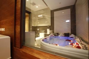 a bathroom with a tub with a toilet in it at Grand Plaza Hotel - Takhasosi Riyadh in Riyadh +42 photos