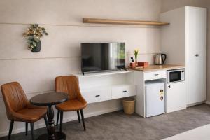 a kitchen with a table and two chairs and a tv at De'Vine Escape in Dixons Creek