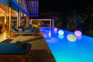 a swimming pool at night with blue lights at The Glasshouse Victoria in Digana