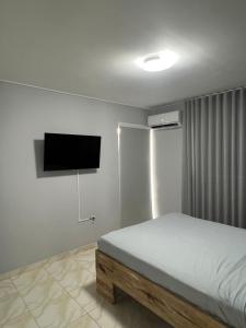 a bedroom with a bed and a flat screen tv at Grey-B Appartment in Dorp Sint Michiel