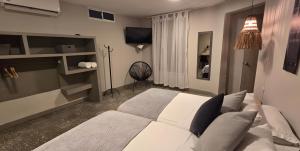 a bedroom with a white bed and a television at Casa Agena in Cartagena de Indias
