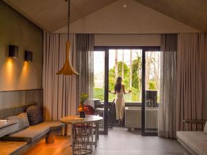 a woman standing in a living room looking out the window at Amorita Resort Palawan in Puerto Princesa