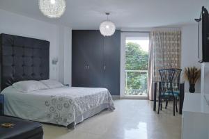 a bedroom with a bed and a chair and a window at Hotel Calima Real in Cali +36 photos