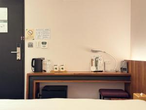 a desk in a hotel room with a bed and a desk at Goodmore Hotel in Taipei