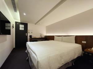 a bedroom with a large white bed in a room at Goodmore Hotel in Taipei