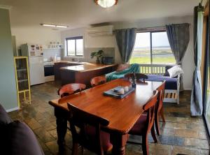 a kitchen and living room with a wooden table and chairs at Riverview Coastal Retreat Sleeps 6 Walk to Beach Great Ocean Road in Peterborough