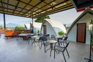 a group of tables and chairs on a patio at Hebe Hotel, Hostel & Hospitality Network in Sawah