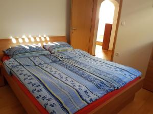 uma cama com um cobertor azul e branco em Apartment Brina em Kranjska Gora
