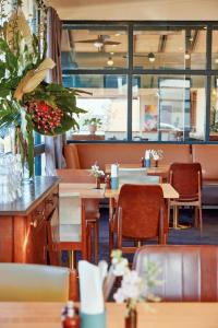 ein Restaurant mit Holztischen und -stühlen und Fenstern in der Unterkunft The Gladdy in Stockton