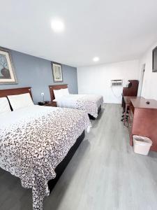 a hotel room with two beds and a desk at Economy Inn in Longview