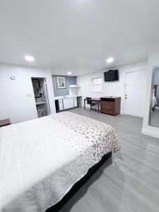 a bedroom with a large white bed and a desk at Economy Inn in Longview