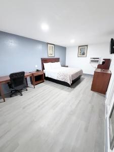 a bedroom with a bed and a desk and a desk at Economy Inn in Longview