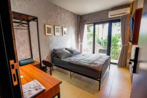 a bedroom with a bed and a table and a window at Hebe Hotel, Hostel & Hospitality Network in Sawah +38 photos