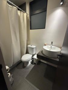 a bathroom with a white toilet and a sink at Luke Stay in El Pueblito
