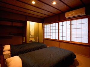 a bedroom with two beds and two windows at Villa near Kinkakuji Pets OK free Parking 金閣寺周辺 貸切町屋 ペットOK 無料駐車場 in Kinugasa