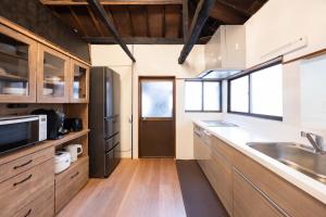 a kitchen with wooden cabinets and a sink at 将軍の隠れ家 in Okayama