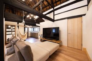 a living room with a couch and a tv at 将軍の隠れ家 in Okayama