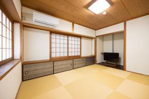 an empty room with a tv and windows at 将軍の隠れ家 in Okayama +6 photos
