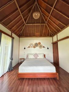 a bedroom with a white bed in a room at Yellow Coco Gili Gede in Gili Gede