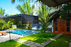 a backyard with a swimming pool and a house at Jungle View Inn in Trincomalee