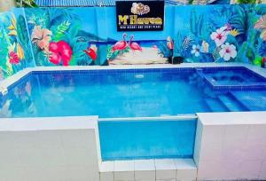 a swimming pool at a resort with a mural of flamingos at M3 Haven Masbate in Masbate