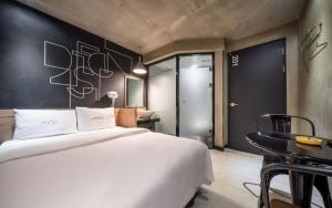 a bedroom with a large white bed and a table at Hotel Piano in Seoul