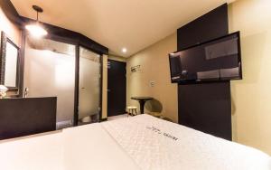 a bedroom with a bed with a flat screen tv at Hotel Piano in Seoul +2 photos