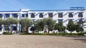 a white building with trees in front of it at Hotel Ribis in Ait Melloul
