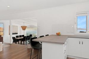 a kitchen and living room with a table and chairs at 180 Degrees - Amazing Bay Views in St Helens