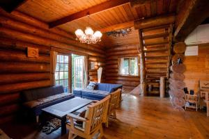 a living room with a couch and a table in a log cabin at Forest Villa Rio Biwako in Takashima
