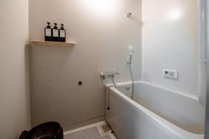 a bathroom with a shower and a tub with bottles on a shelf at Forest Villa Rio Biwako in Takashima +52 photos