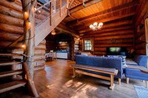a living room with a blue couch in a log cabin at Forest Villa Rio Biwako in Takashima