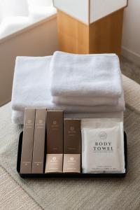 a pile of towels and a pile of products on a bed at KIORI Hotel Teramachi in Kyoto