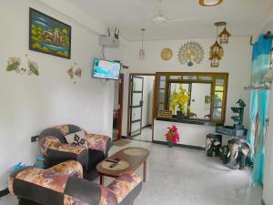 a living room with couches and a flat screen tv at Haritha Villa Yala in Kirinda