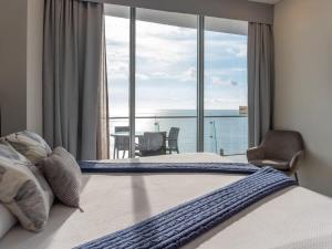 a bedroom with a bed with a view of the ocean at Luxe Oceanfront Condo in Golden Zone in Mazatlán