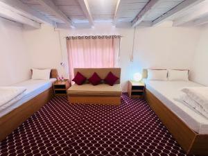 a room with two beds and a chair in it at Hotel Dancing Yak in Jomsom