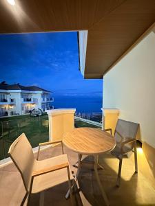 a table and chairs on a balcony with a view of the ocean at The Lake Hotel Tagaytay in Tagaytay