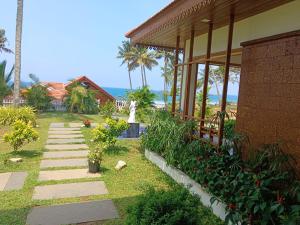 a walkway next to a house with the ocean in the background at Flower Hill Cottage in Varkala