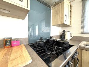 a kitchen with a stove with three pots on it at Cedar Retreat in Scarborough