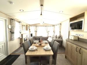 a dining room with a table and chairs in a caravan at Cedar Retreat in Scarborough