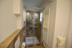 prysznic ze szklanymi drzwiami w łazience w obiekcie Colonna Terrace Apartment we Florencji +16 zdjęć
