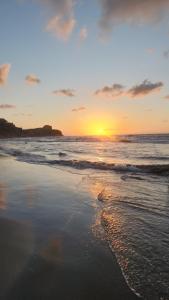 a sunset on a beach with the ocean at Casa de Playa Salgar in Puerto Colombia