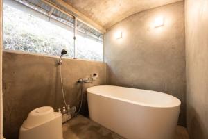 a bathroom with a bath tub and a window at 将軍の隠れ家 in Okayama
