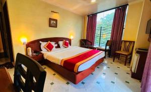 ein Hotelzimmer mit einem Bett und einem Fenster in der Unterkunft Tekareesinn in Lucknow