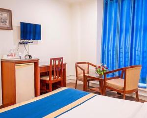 ein Hotelzimmer mit Bett, Schreibtisch und Stühlen in der Unterkunft Tekareesinn in Lucknow + 5 Fotos