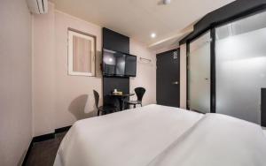 a hotel room with a white bed and a table at Hotel Piano in Seoul