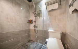 a bathroom with a toilet and a glass shower at Hotel Piano in Seoul