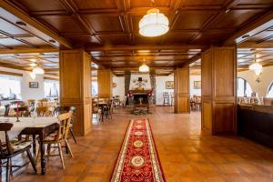 a dining room with tables and chairs and a fireplace at Villa Siana in Bran