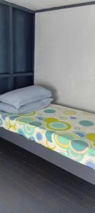 a bed with a colorful blanket on top of it at Knox's Beachfront Homestay in Nalauwaki