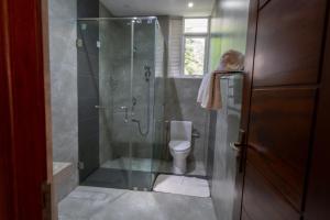a bathroom with a glass shower with a toilet at HillCrest Hotel in Kandy +24 photos
